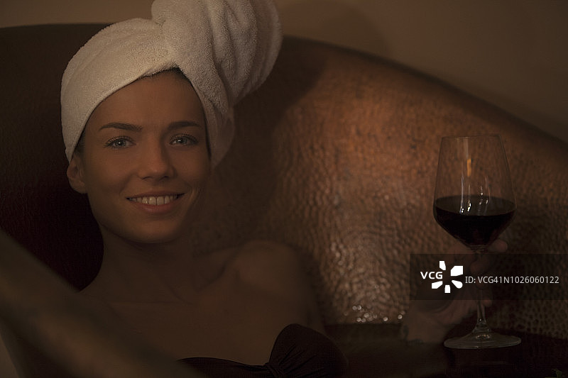 在浴缸里手持一杯葡萄酒的女人图片素材