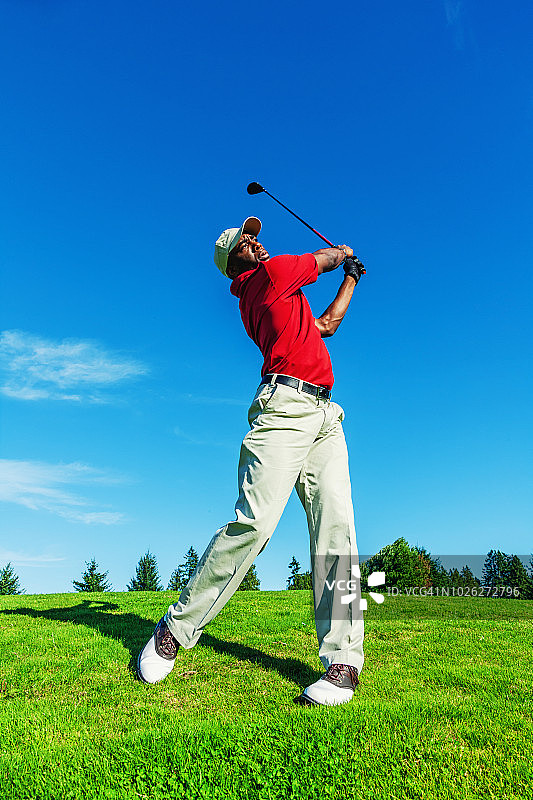 高尔夫球手在球场挥杆击球图片素材