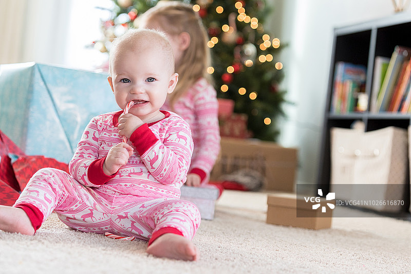 女婴在圣诞节期间咀嚼糖果图片素材