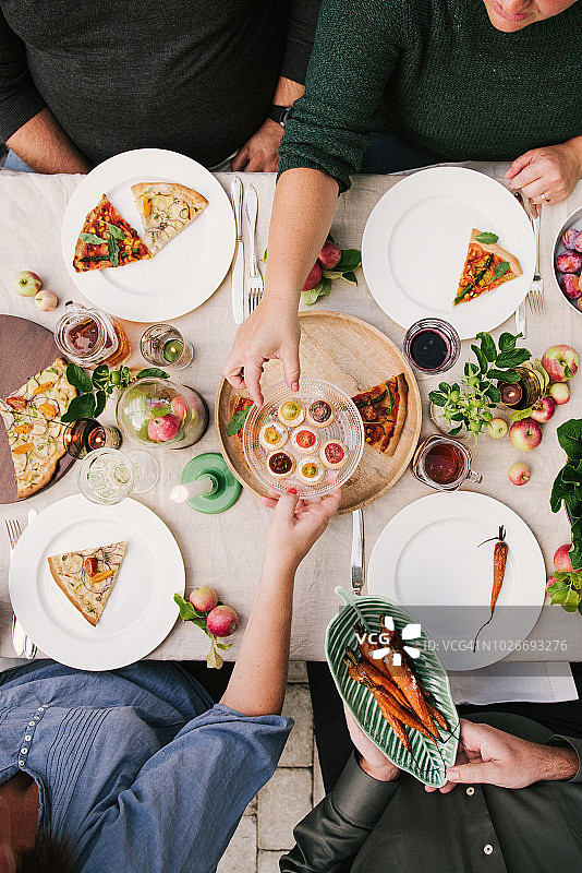 朋友们在温室丰收派对上共进晚餐图片素材