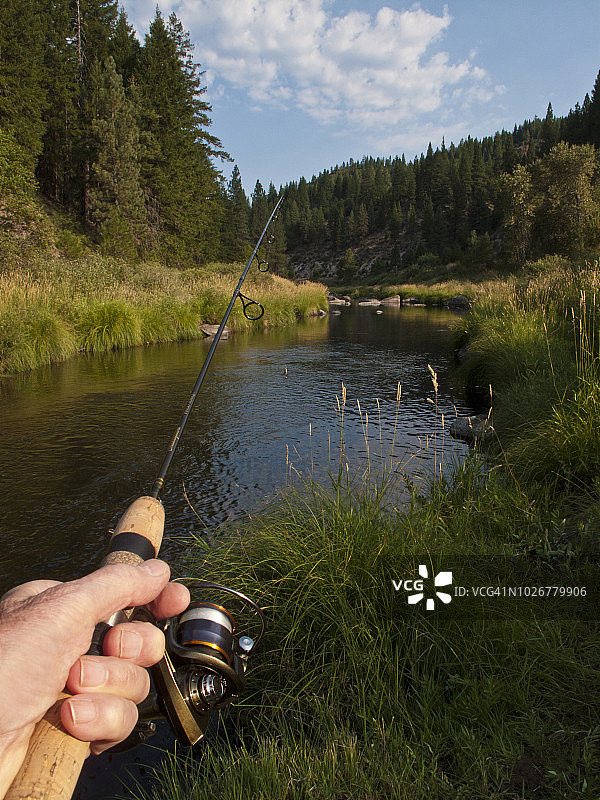 男子在加州格雷伊格尔羽毛河手持鱼竿甩杆钓鱼特写图片素材