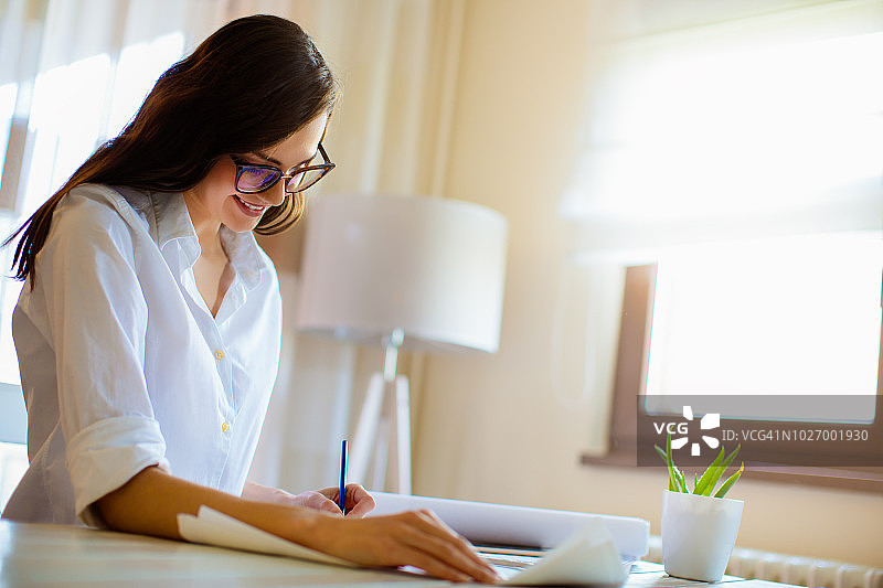 女建筑师在蓝图上工作图片素材