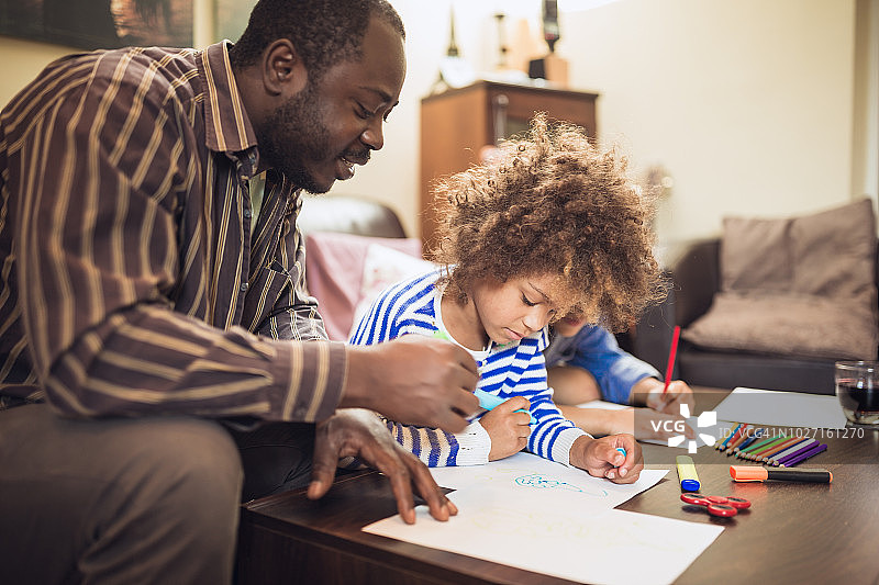 父亲和孩子们在家做作业图片素材