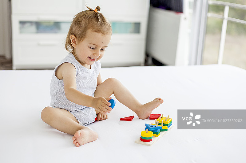 可爱小女孩玩木制玩具图片素材