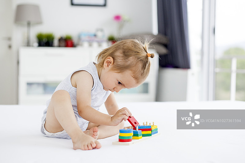 可爱小女孩玩木制玩具图片素材