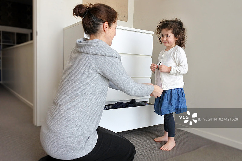 在母亲的帮助下打扮的年轻女孩图片素材
