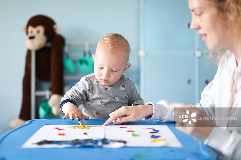 一个男婴和他的母亲一起进行手指画图片素材