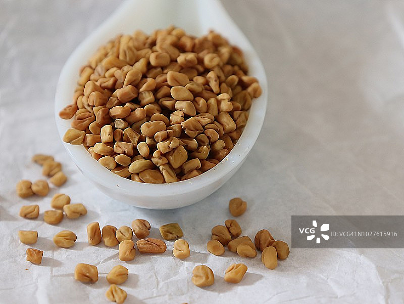 陶瓷勺中的胡芦巴籽特写图片素材