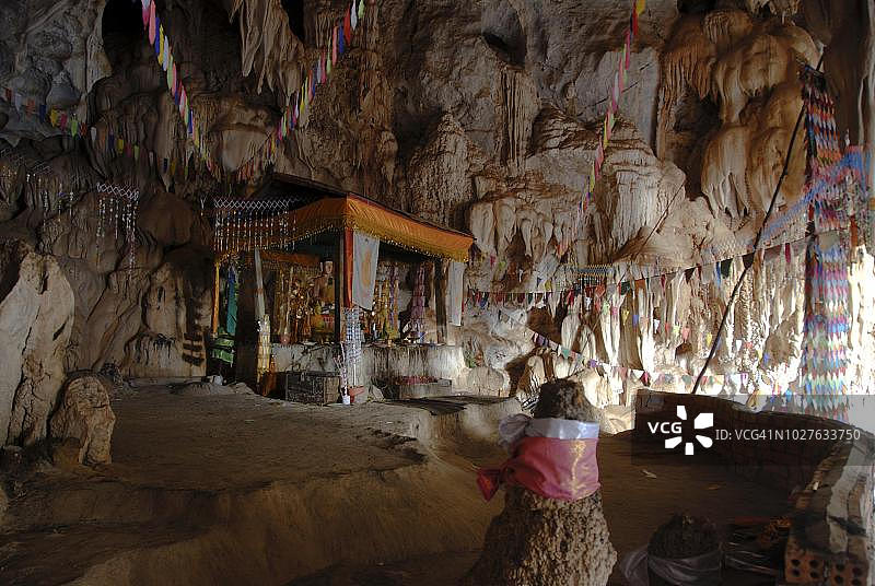 在老挝甘蒙省他曲的Tham Pha In洞穴中进行探洞活动，洞穴内有小寺庙、佛像和石笋，洞穴探险图片素材