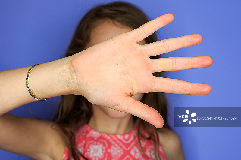 用手遮住自己的年轻女孩图片素材