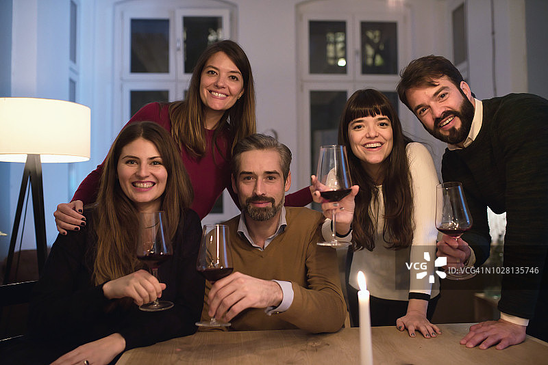 朋友们在桌边举着酒杯的合影图片素材