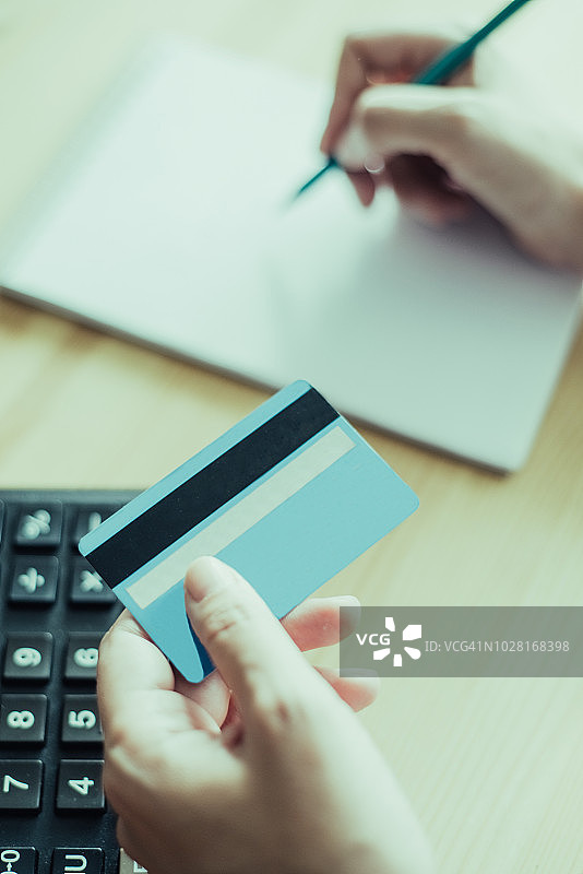 银行家拿着信用卡写作的特写图片素材