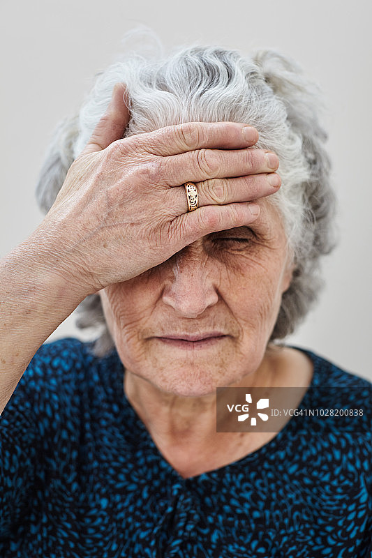 年长的女人扶着额头图片素材