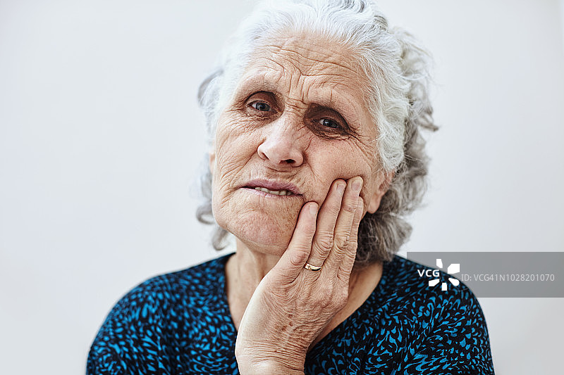 老妇因牙痛而触摸脸颊图片素材