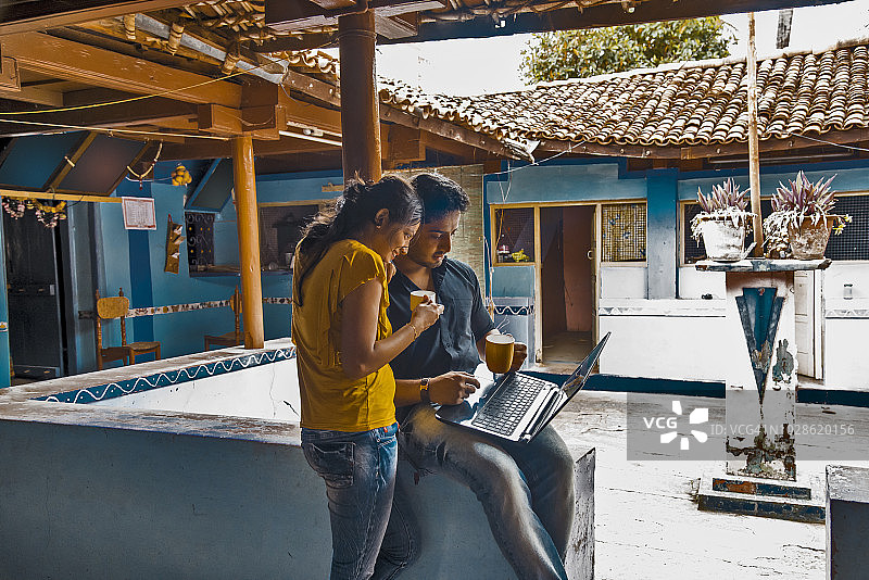 年轻情侣在农舍里使用笔记本电脑图片素材