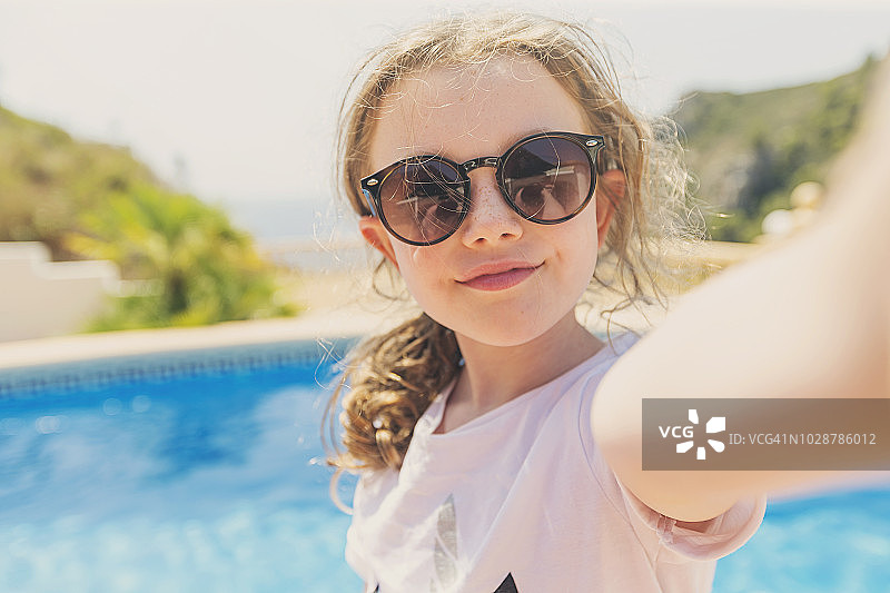 在泳池边自拍的年轻女孩图片素材