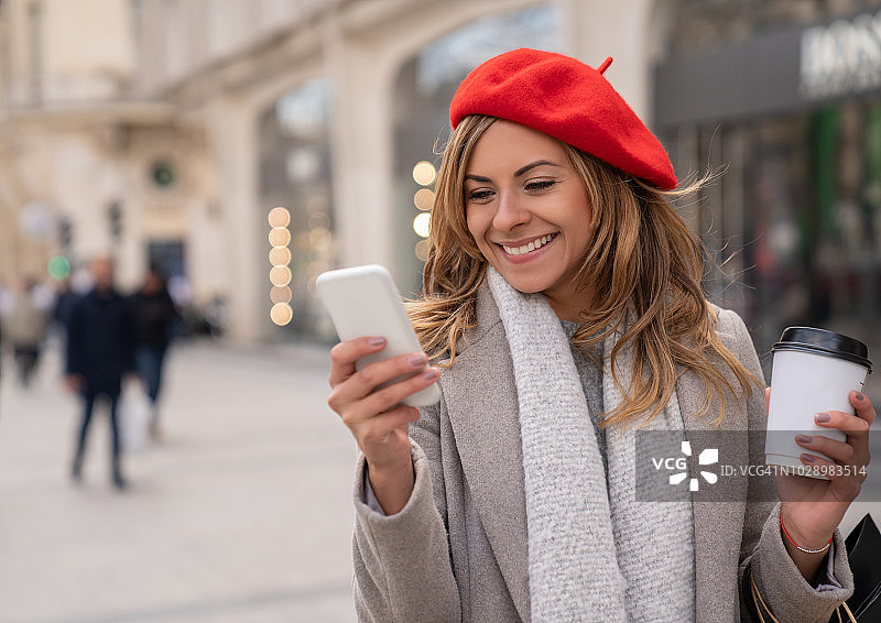 发短信和喝咖啡的漂亮女购物者图片素材