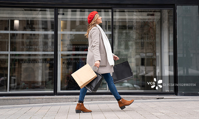快乐的女顾客在巴黎购物图片素材