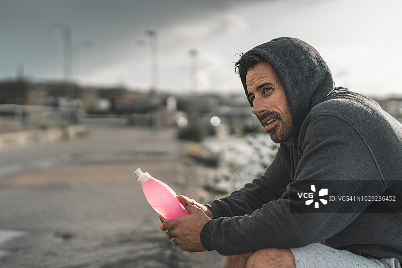 雨天户外运动后男人坐着休息图片素材
