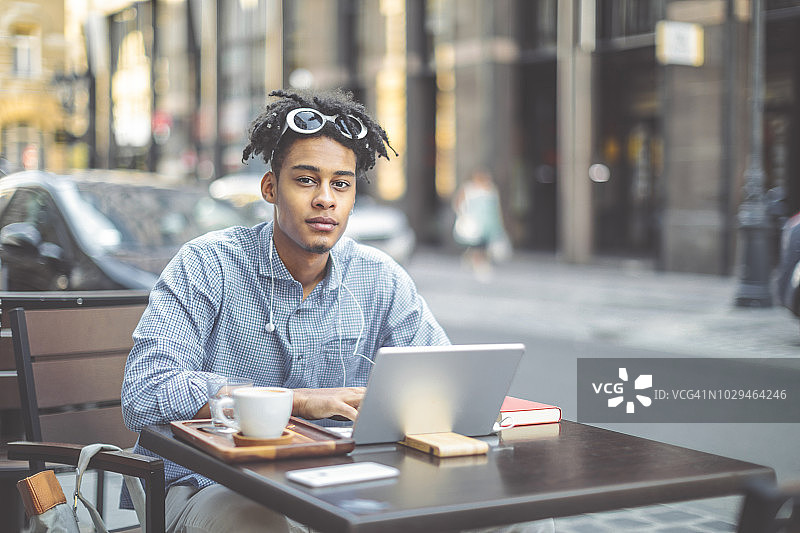 自信青年在市中心享受咖啡休息时光图片素材