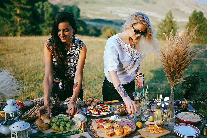 在乡下准备野餐食物的年轻女人图片素材
