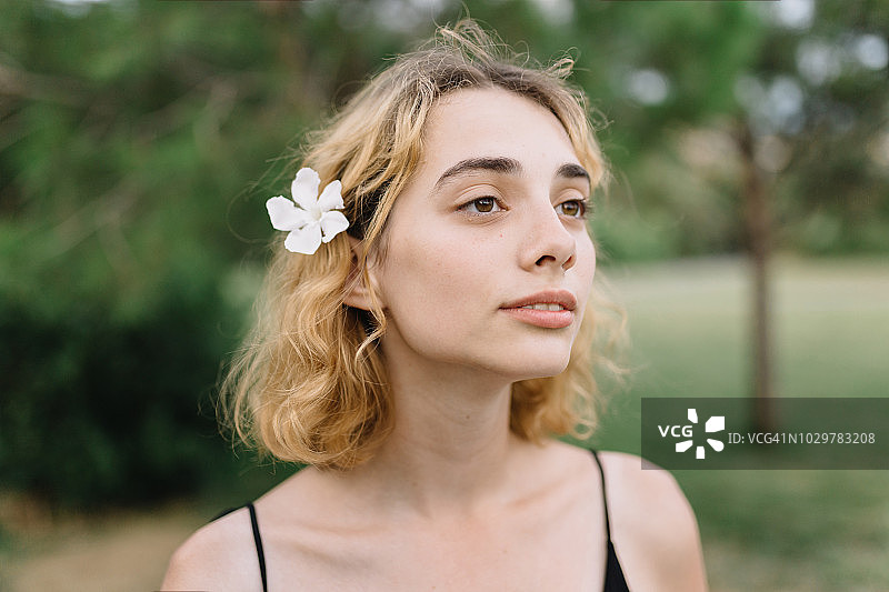 头发上戴着白花的年轻女人图片素材