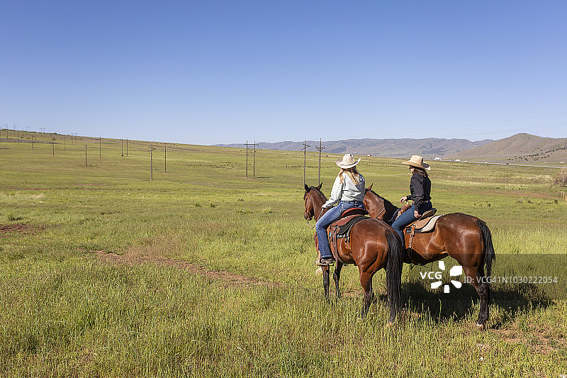 两名女牛仔在马背上交谈图片素材