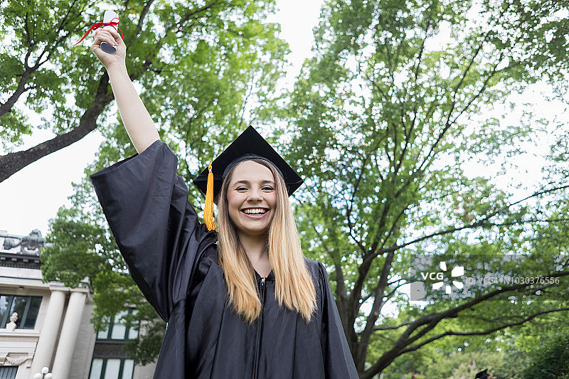 大学毕业生自豪地展示毕业证书图片素材