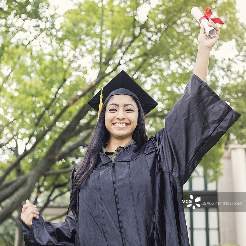 自豪的女大学生拿着毕业文凭图片素材