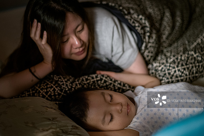 母亲在家看着儿子睡觉的肖像图片素材