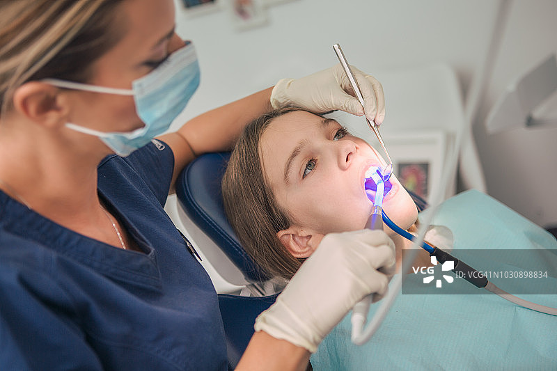 儿童牙科：牙医检查年轻女孩图片素材