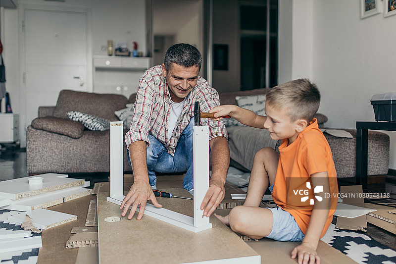 单亲爸爸和孩子们一起组装家具图片素材