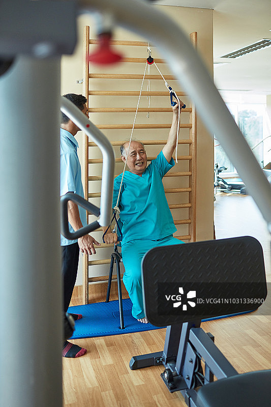 男护士在医院健身房指导病人锻炼图片素材