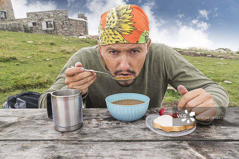 男人在户外喝汤图片素材