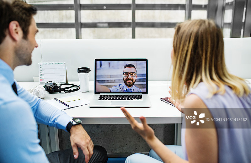 在办公室里进行视频通话的两位年轻商务人士图片素材