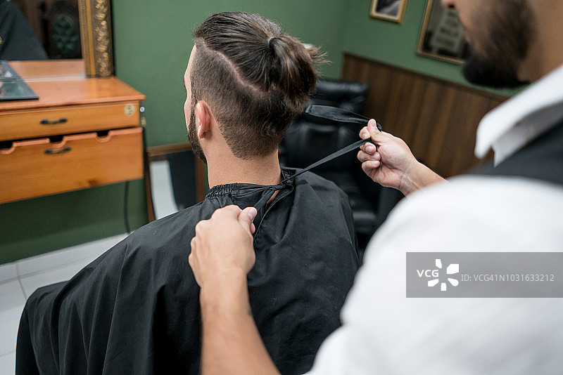 理发师为男顾客系理发披肩图片素材
