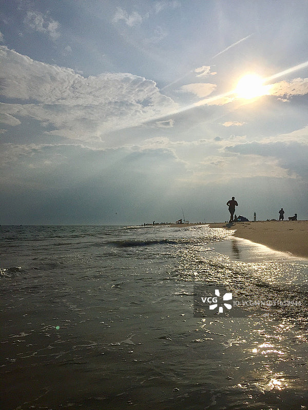 魔幻时刻：日落时分海洋沙滩上的阳光图片素材