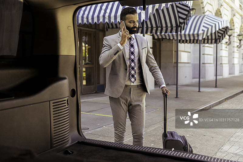 离开豪华酒店，等待豪华轿车的商人图片素材