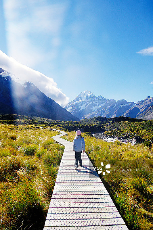 在胡克谷步道木板路上行走，远眺库克山的女孩图片素材