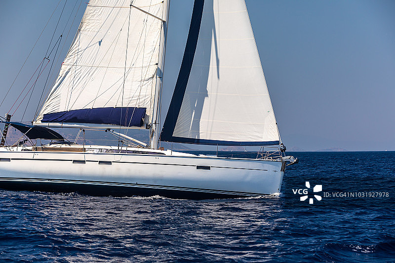 在平静的海面上航行的孤独游艇，希腊图片素材