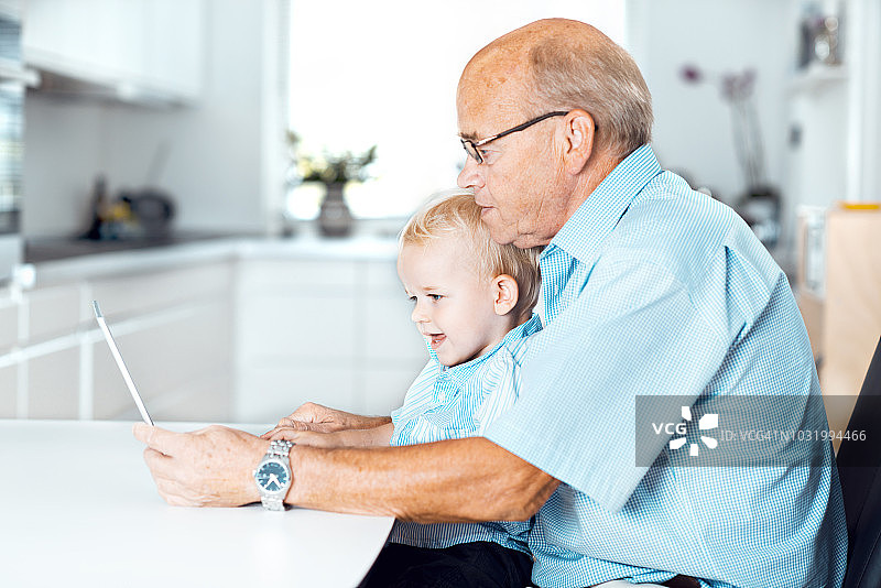 小孩和爷爷在家一起使用电脑图片素材