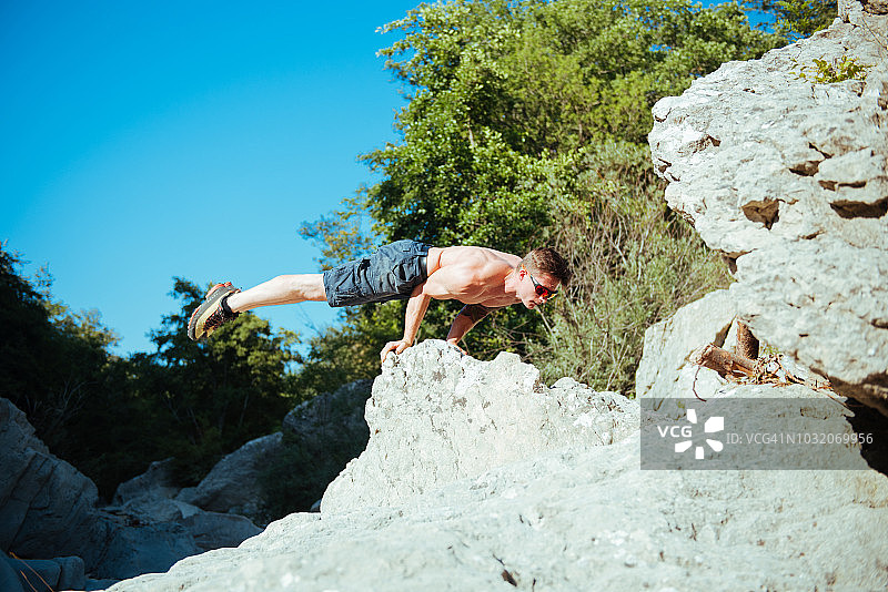 男人在意大利托斯卡纳阿雷佐的溪流边用手保持平衡图片素材