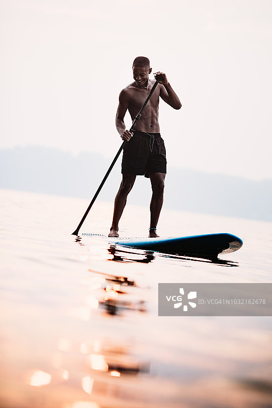 年轻男子在夏季的普吉特海湾玩桨板图片素材