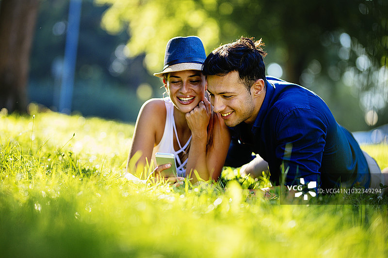 年轻夫妇在户外看手机图片素材