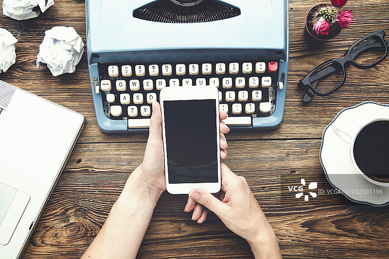 在办公室使用手机的女人（顶视图）图片素材