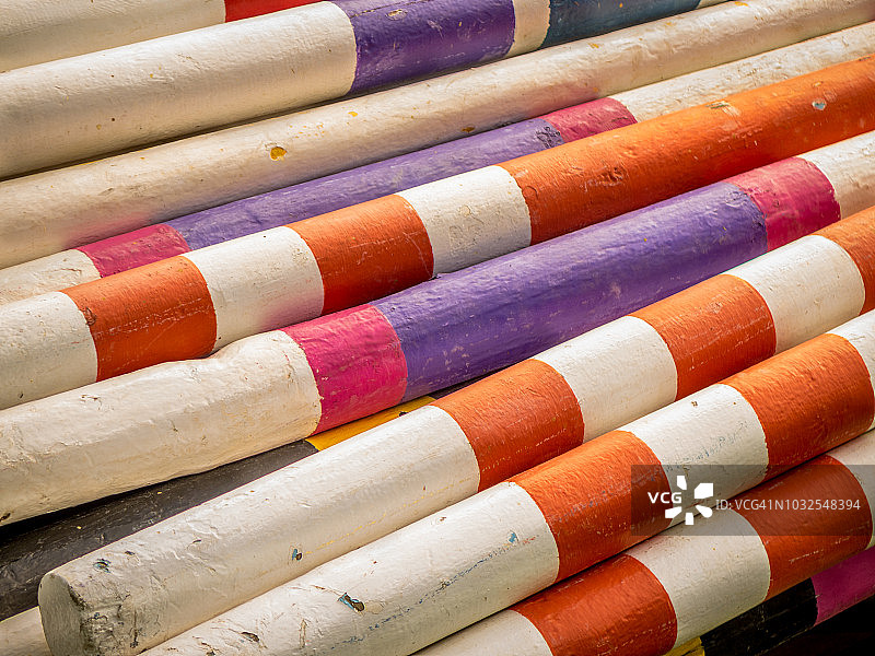 马术障碍赛：竞技场角落堆放的彩色障碍杆图片素材