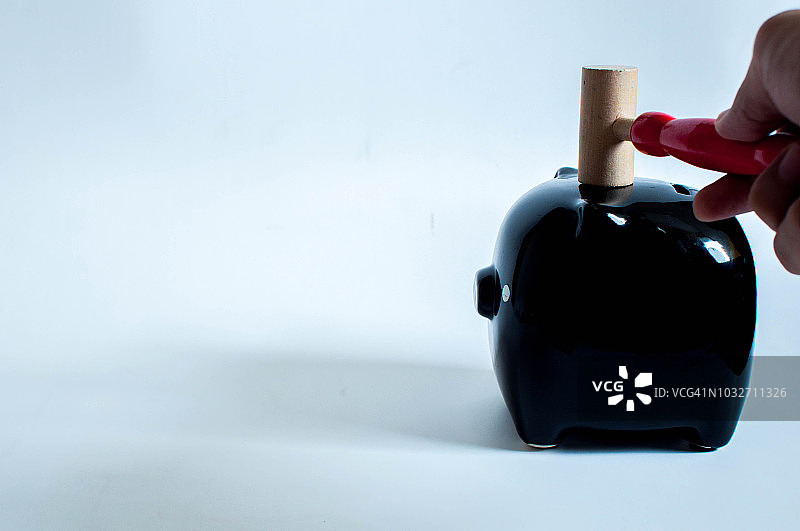 打开黑色小猪储蓄罐与锤子图片素材