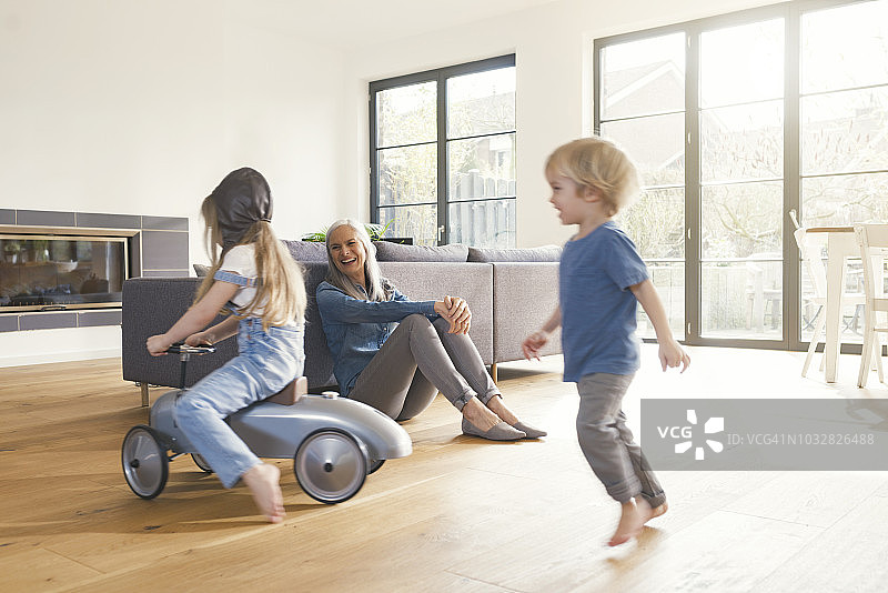 祖父母看着祖母在客厅里玩耍图片素材