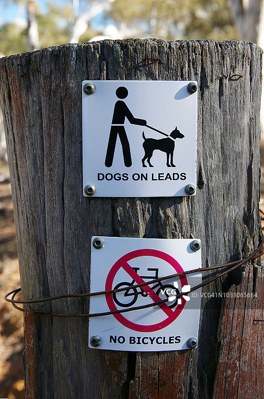 澳大利亚首都领地马朱拉山自然保护区木栅栏上的“禁止自行车”和“牵狗”标志图片素材