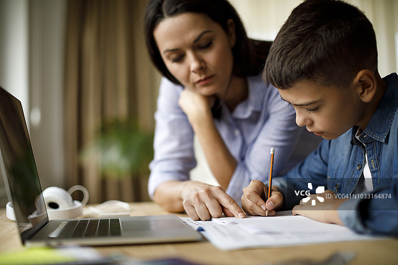母亲辅导青少年做作业图片素材